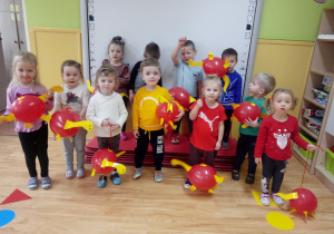 Przedszkolaki bawią się dinozaurami zrobionymi z balonów